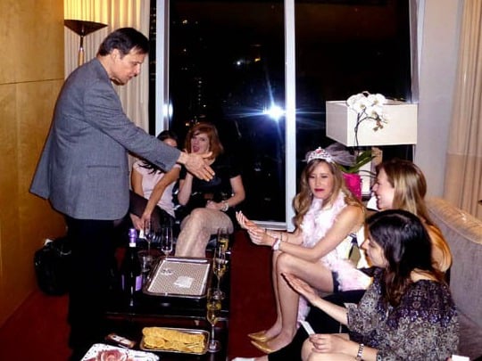 Mister Vibe speaks to a group of women in a hotel room.