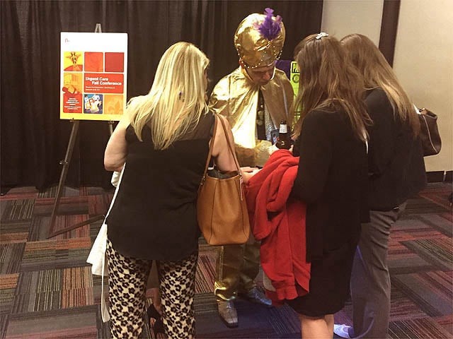 Mister Vibe reads the palms of a group of people at a trade show.