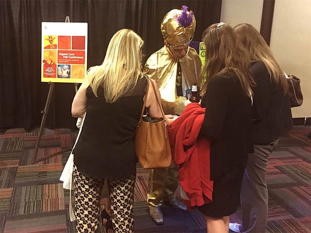 Mister Vibe reads the palms of a group of people at a trade show.