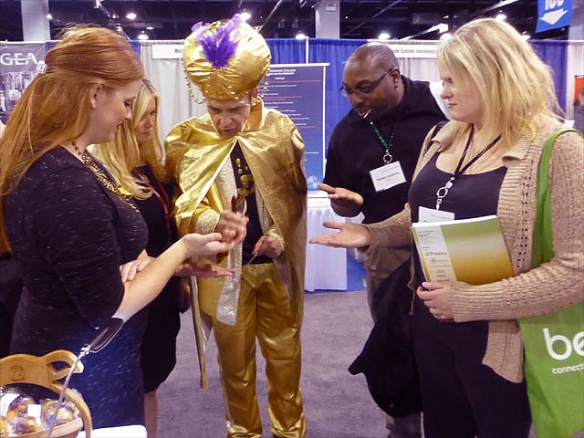 Mister Vibe reads the palms of a group of people at a trade show.