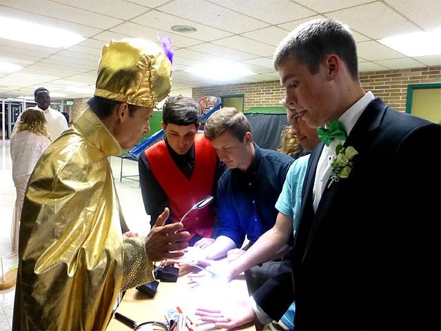 Mister Vibe reads palms of a group of teen boys at an after prom party.